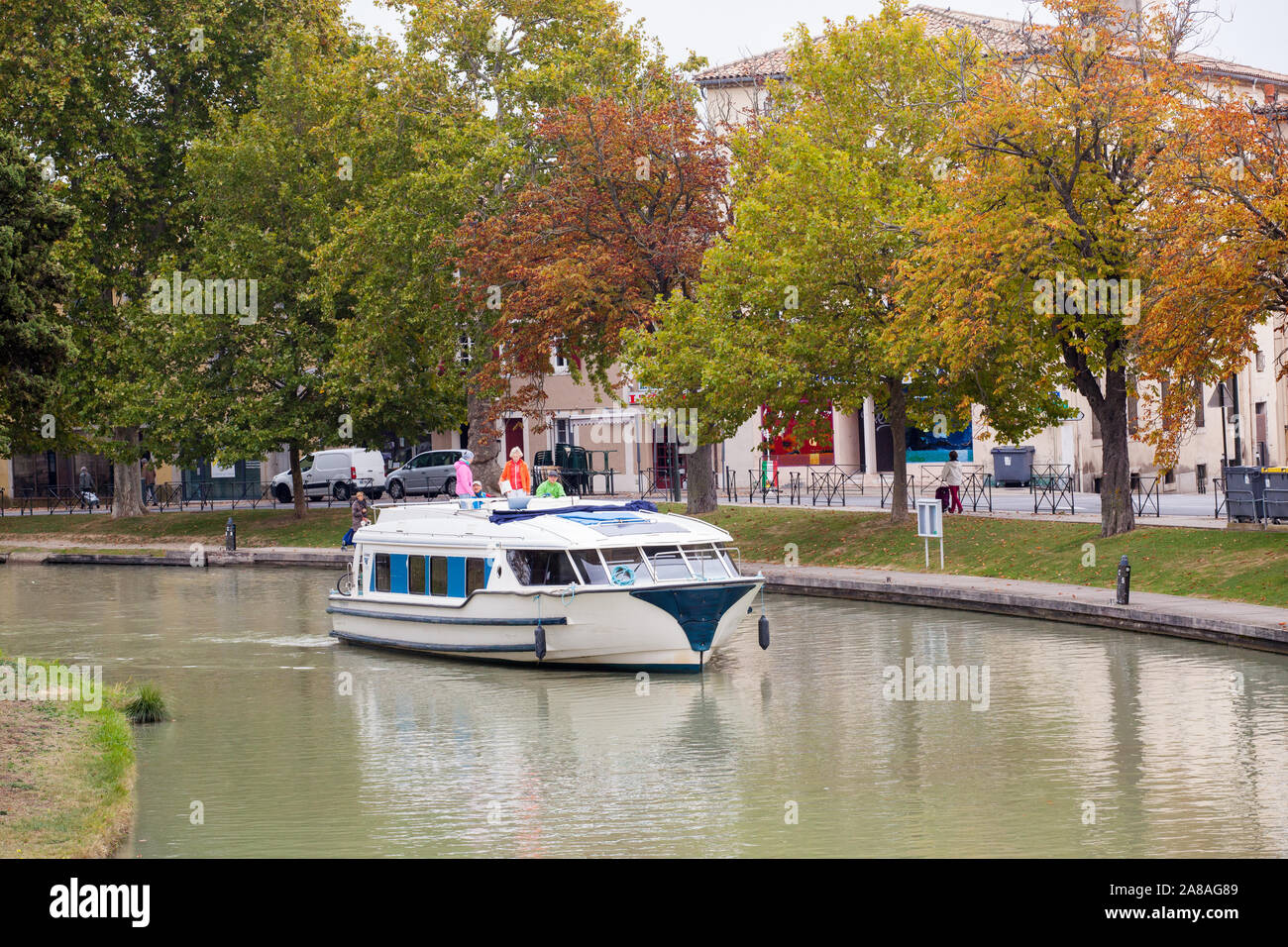 Family people driving a pleasure boat on the Canal du Midi in the French town of Carcassonne France during Autumn Stock Photo