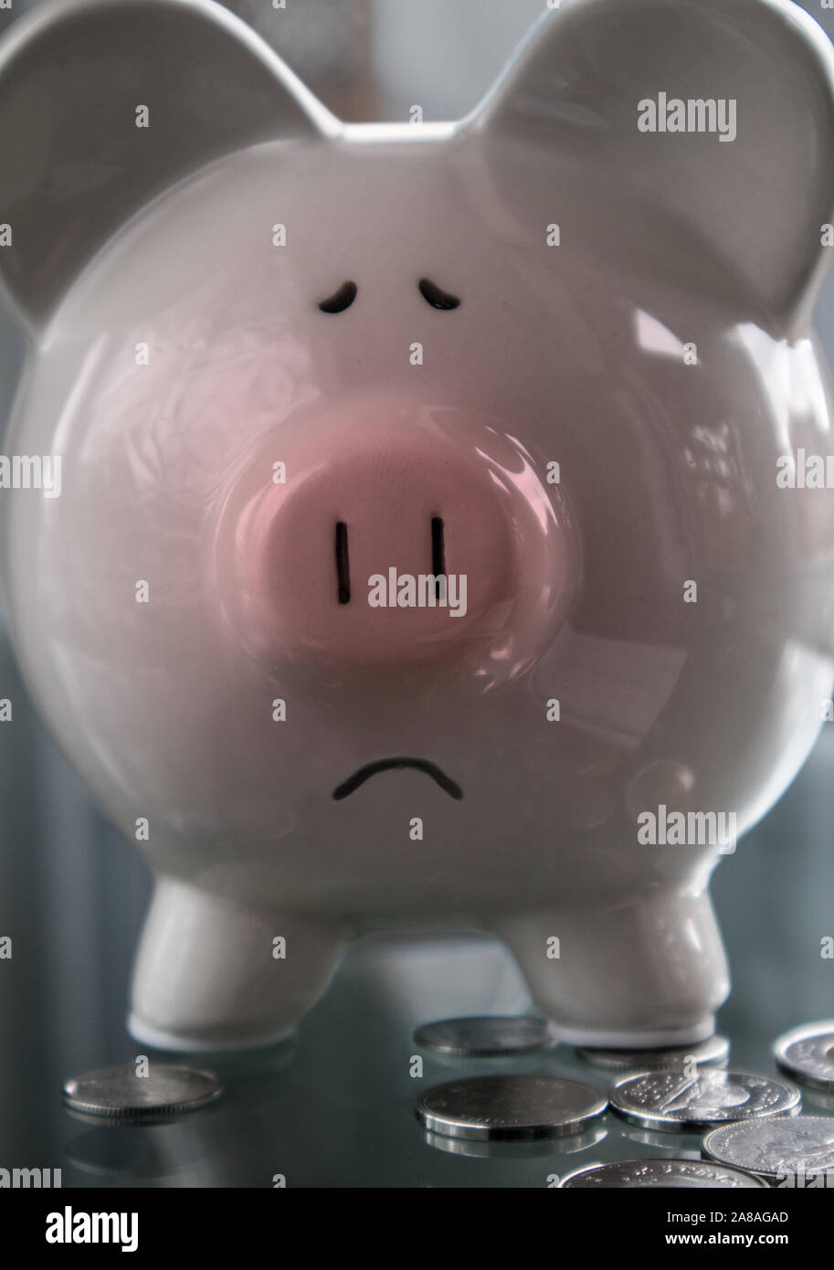 Sad piggy bank (has few coins)... Stock Photo