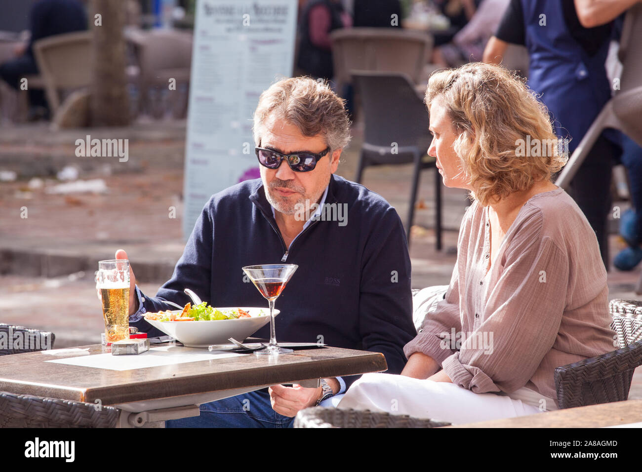 Man woman couple eating and drinking at a pavement cafe outdoors in the French town of Carcassonne France Stock Photo