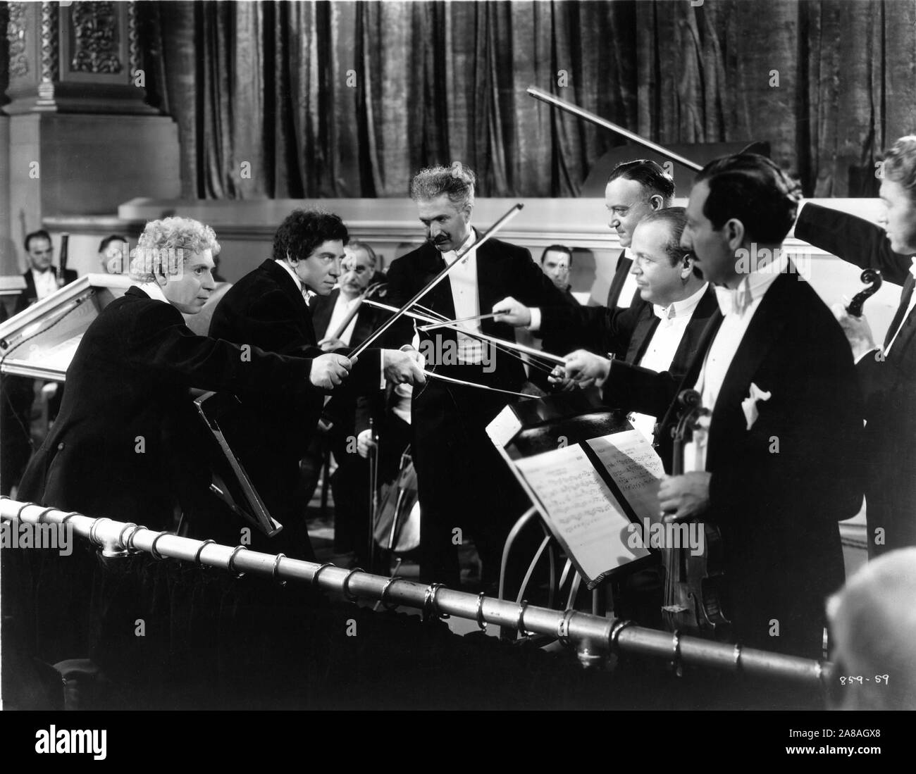 HARPO MARX CHICO MARX and JOHN ST.POLIS as the Conductor in A NIGHT AT THE OPERA 1935 director Sam Wood screenplay George S. Kaufman and Morrie Ryskind producer Irving Thalberg Metro Goldwyn Mayer Stock Photo