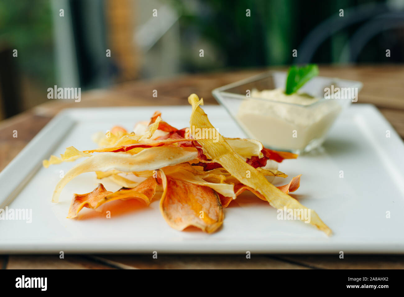 hummus with root vegetable color chips in restaurant Stock Photo Alamy