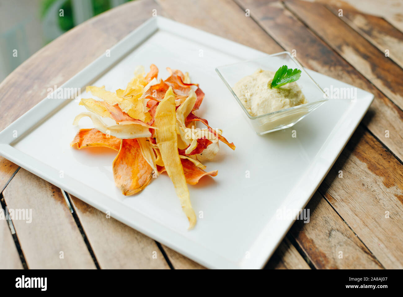 hummus with root vegetable color chips in restaurant Stock Photo