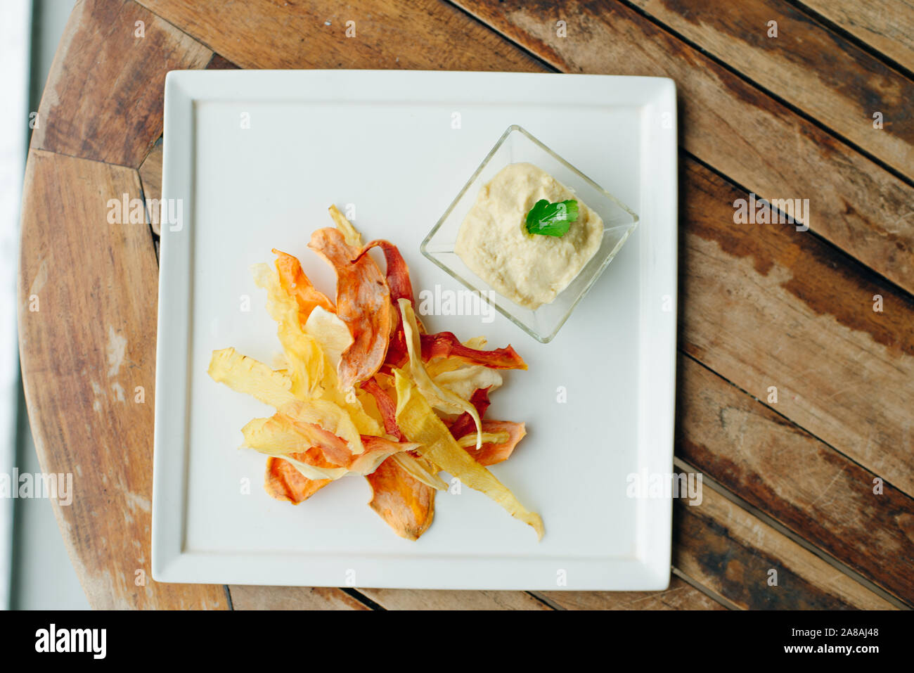 hummus with root vegetable color chips in restaurant Stock Photo