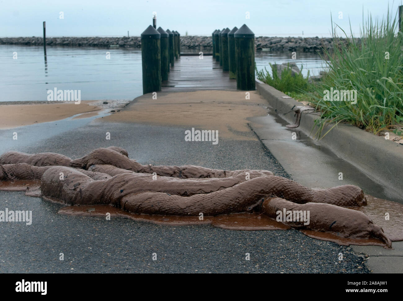 An oil-soaked absorbent boom lies discarded in front of a pier after the BP oil spill in Gulfport, Mississippi, June 30, 2010. Stock Photo
