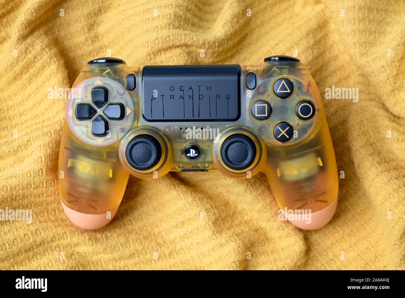KIEV, UKRAINE - November 07, 2019: Death Stranding Limited Edition PS4 Pro.  Transparent dualshock controller for PlayStation 4 on yellow fabric Stock  Photo - Alamy