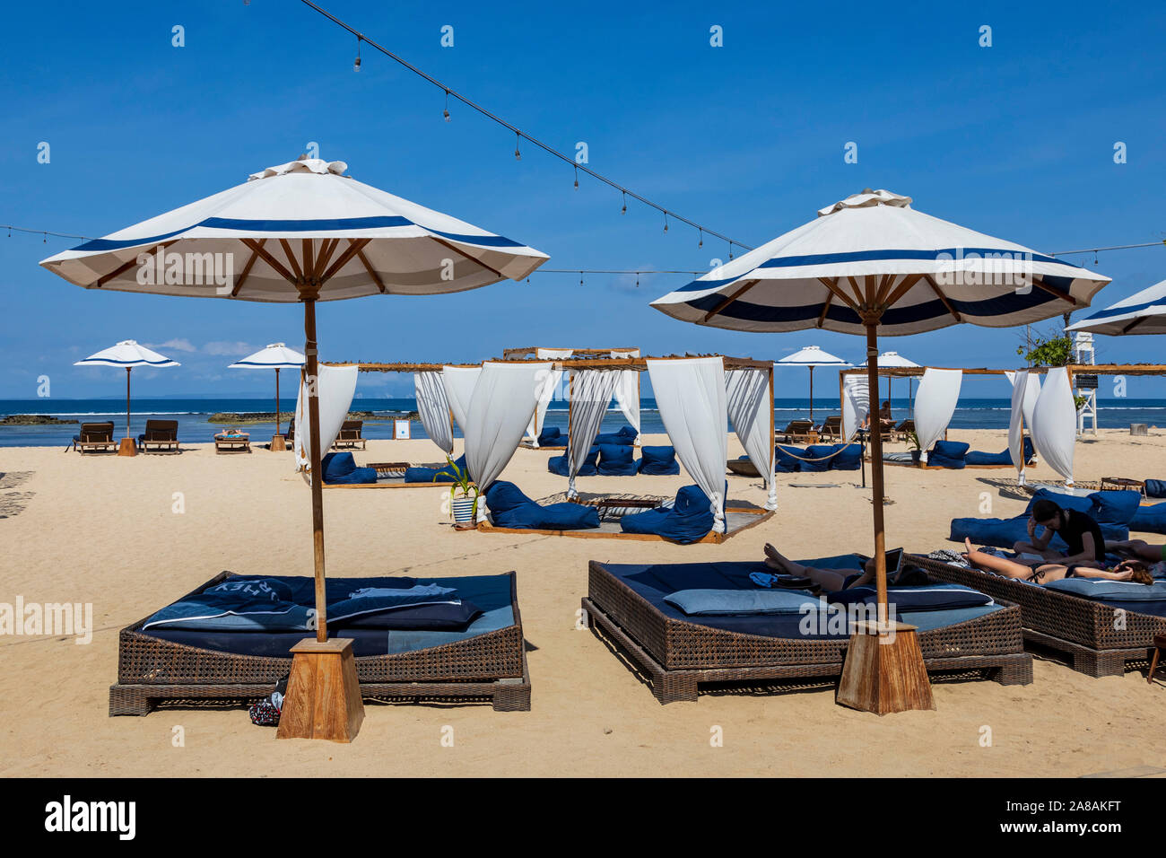 Luxury sun loungers or canopy beach beds and parasols on the beach of ...