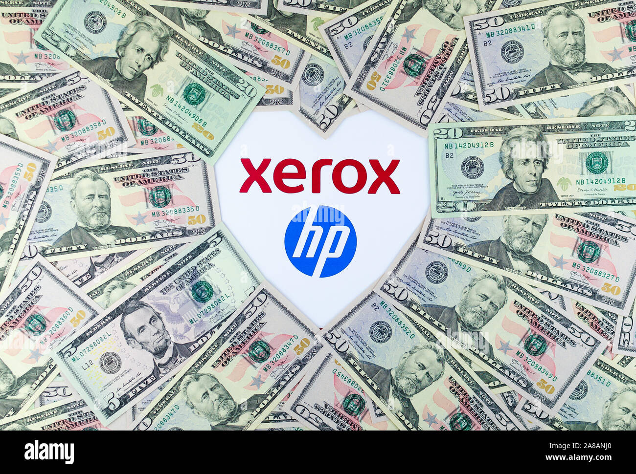 XEROX and HP logos on the paper brochure and dollar bills placed around in a shape of heart. Illustrative for the news about potential merger. Stock Photo
