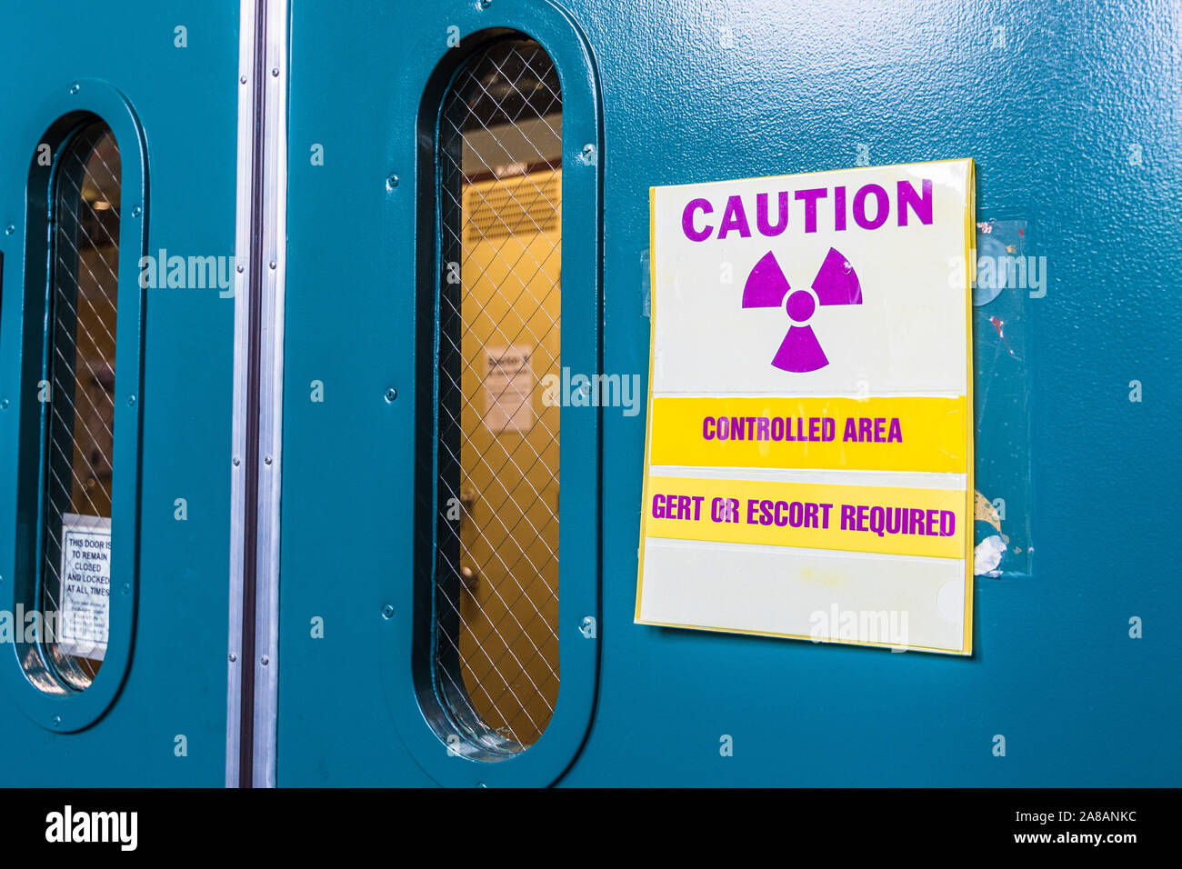 Ionizing radiation warning symbol displayed at the entrance to a laboratory; Message posted: 'Controlled Area; Gert or Escort Required'; Gert stands f Stock Photo