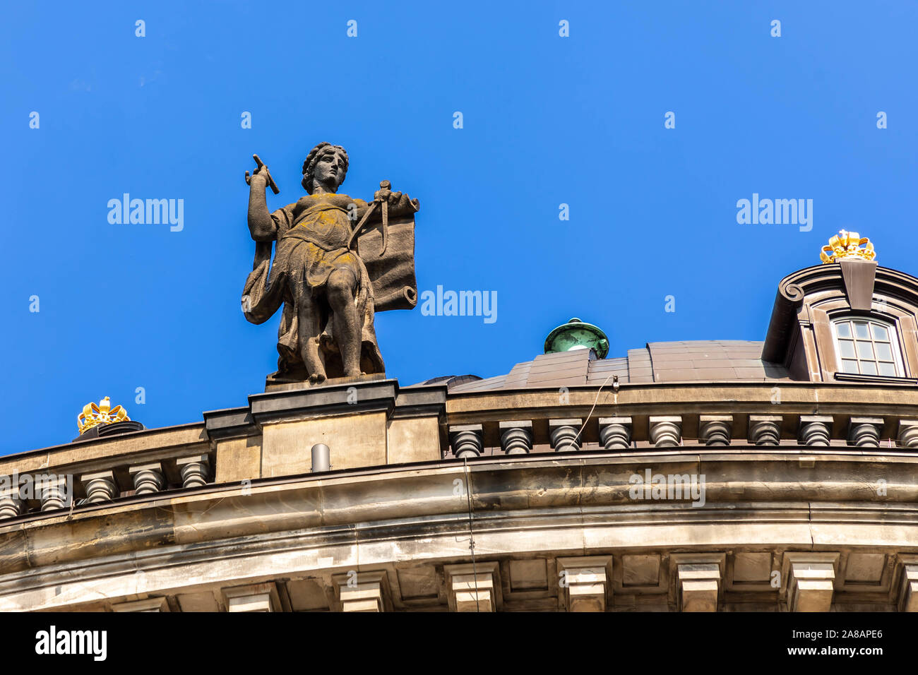 An unnamed female statue atop the Bode Museum holding ancient measurment tools. Pencil, caliper, divider, or  compass and paper. Stock Photo