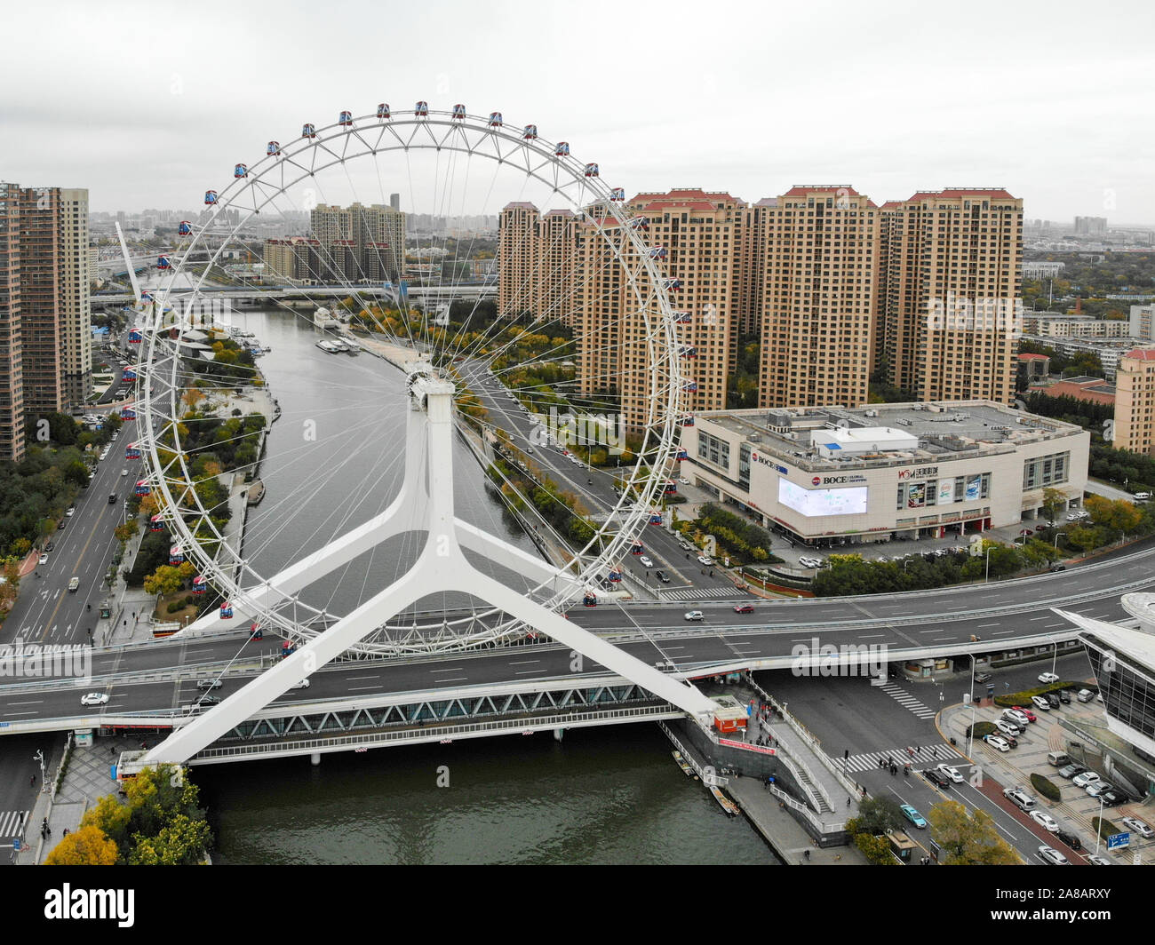 Aerial view cityscape of Tianjin ferris wheel. Famous Tianjin Eye ferris wheel above the Yongle Bridge and the Haihe river. Popular modern landmark in Tianjin, China. October, 28th, 2019 Stock Photo