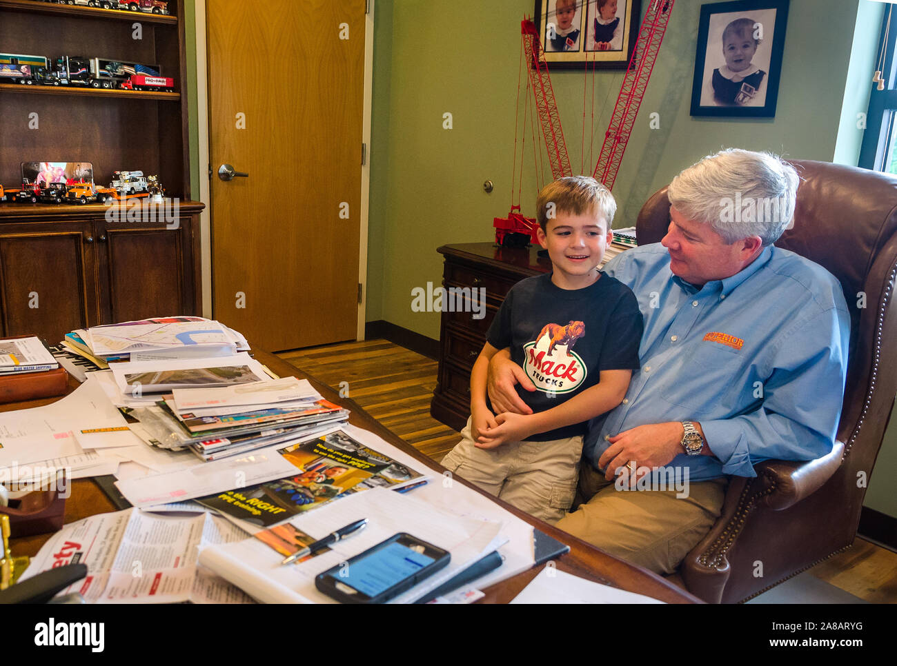 A boy greets his father as he drops by Superior Transportation to visit and “work with dad,” Sept. 30, 2015, in North Charleston, South Carolina. Stock Photo