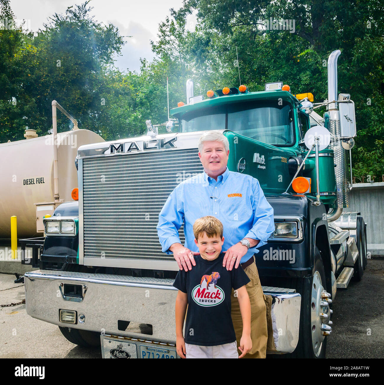 A man stands in front of an antique Mack truck with his son at Superior Transportation, Sept. 30, 2015, in North Charleston, South Carolina. Stock Photo