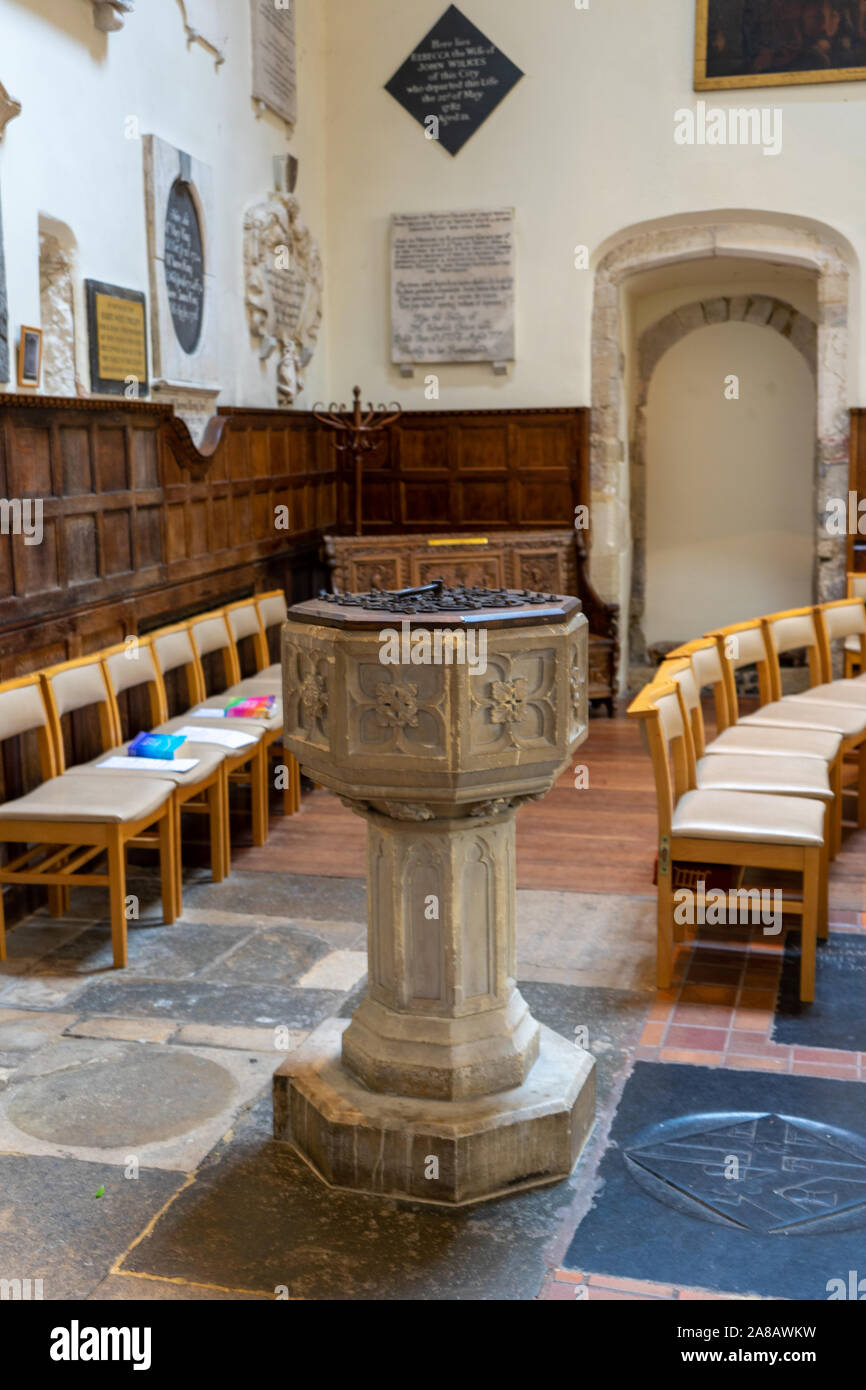 a stone baptismal font or baptism font in an old english church Stock Photo