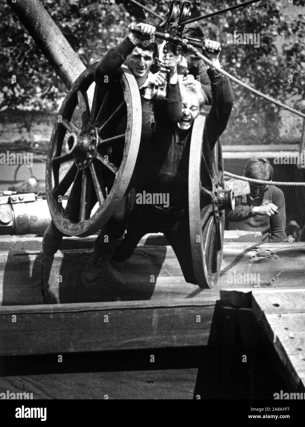 AJAXNETPHOTO. 1984. GOSPORT, ENGLAND. - FIELD GUN TRAINING - WHEELS UP! - FLEET AIR ARM FIELD GUN TEAM PRACTICE CROSSING THE CHASM FOR THE EARLS COURT, LONDON, ROYAL TOURNAMENT COMPETITION AT THEIR TRAINING GROUND AT HMS DAEDALUS. PHOTO: JONATHAN EASTLAND/AJAX REF:1984 8 Stock Photo