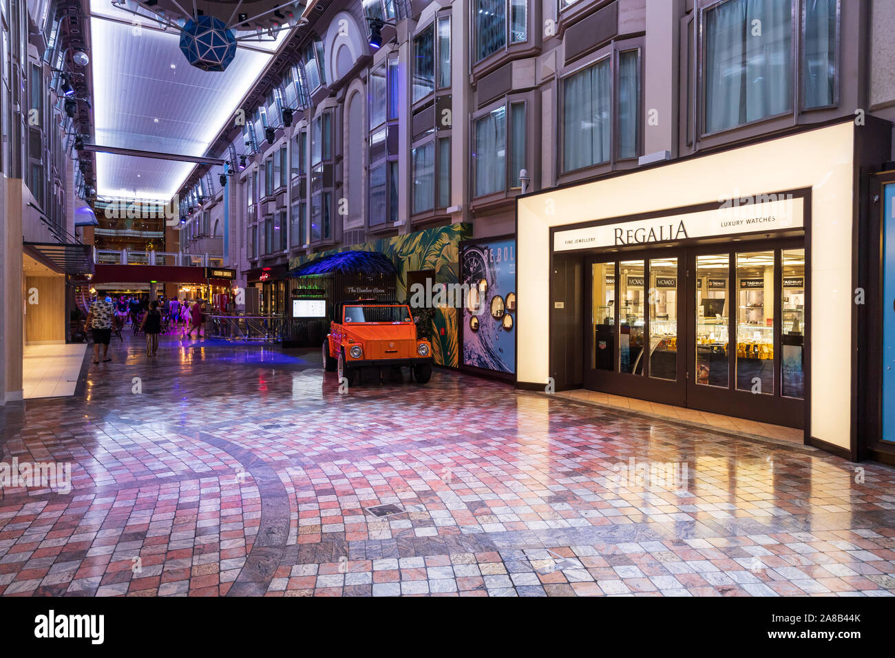 The Royal Promenade, aboard a Royal Caribbean cruise ship, features multiple restaurants and stores to shop in for the guests aboard. Stock Photo