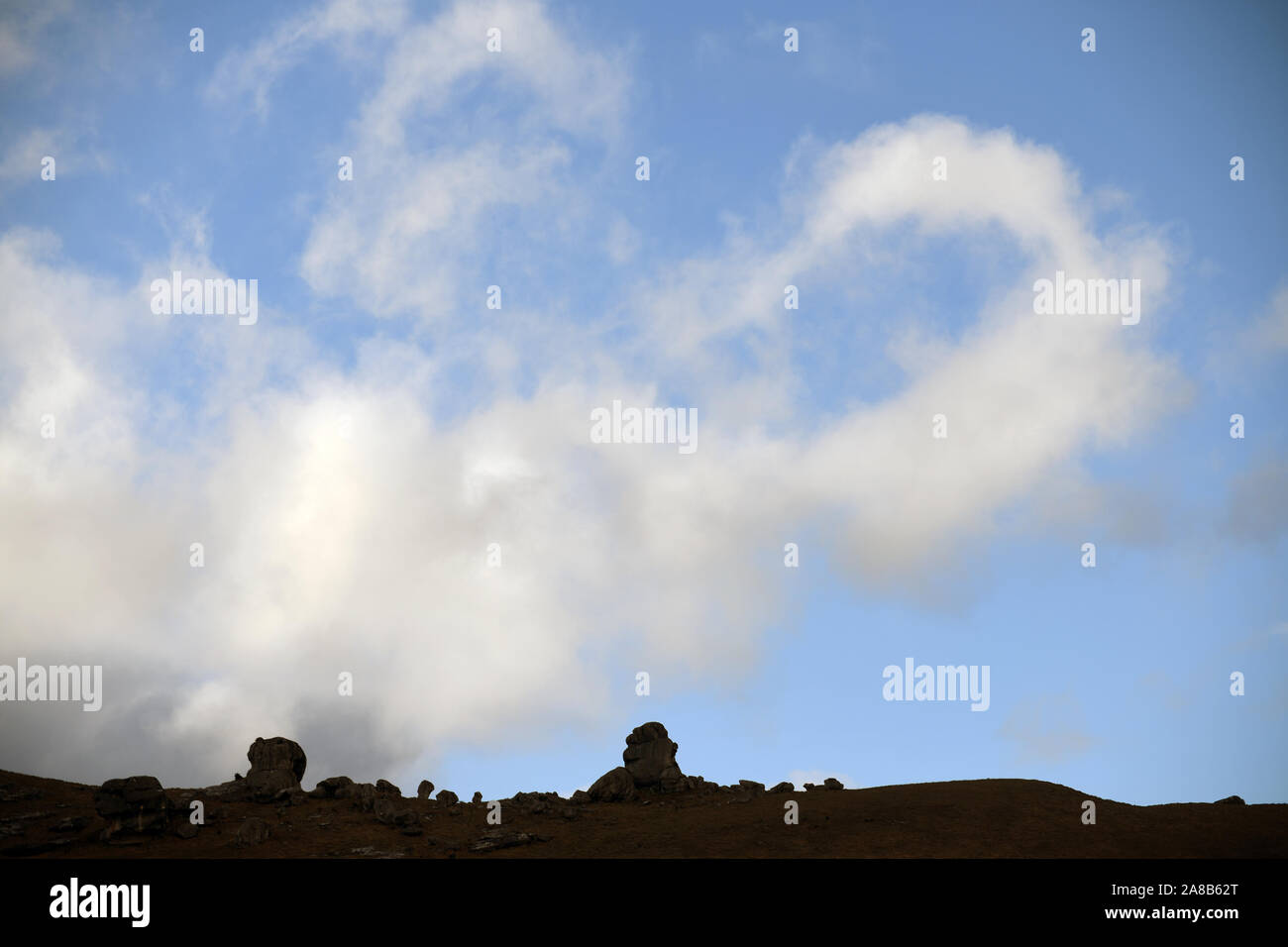 Strange cloud formations waft over the rocky landscape at Castle Hill, South Island, New Zealand Stock Photo