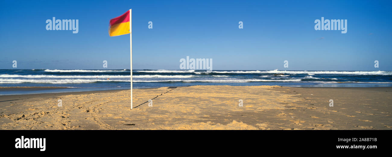 Flag fluttering on the beach, Nobby's Beach, Newcastle, New South Wales, Australia Stock Photo