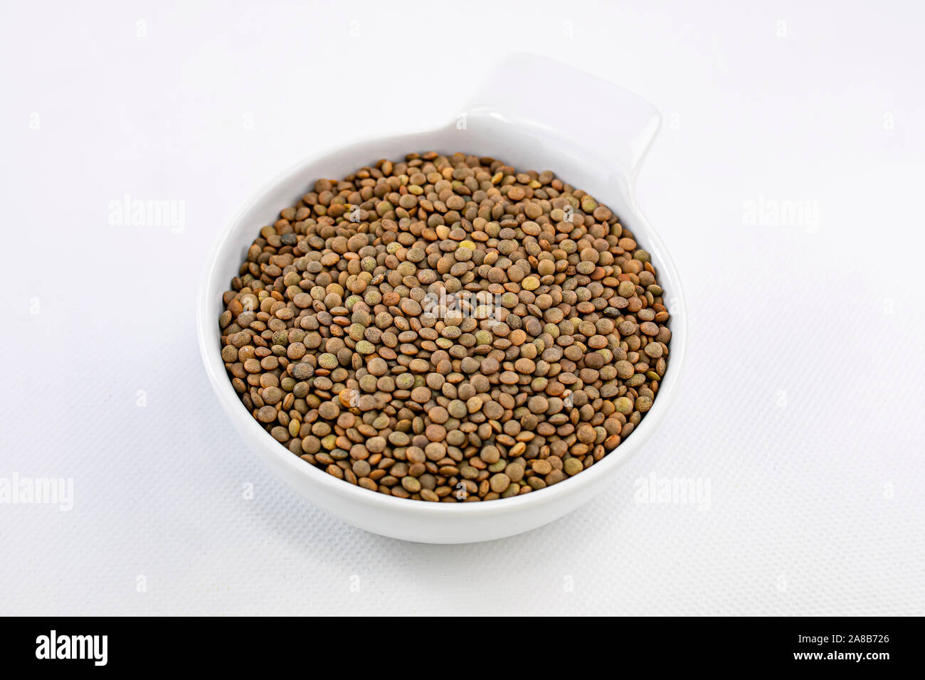 Top view and close up of a bowl with lentils on white background Stock Photo