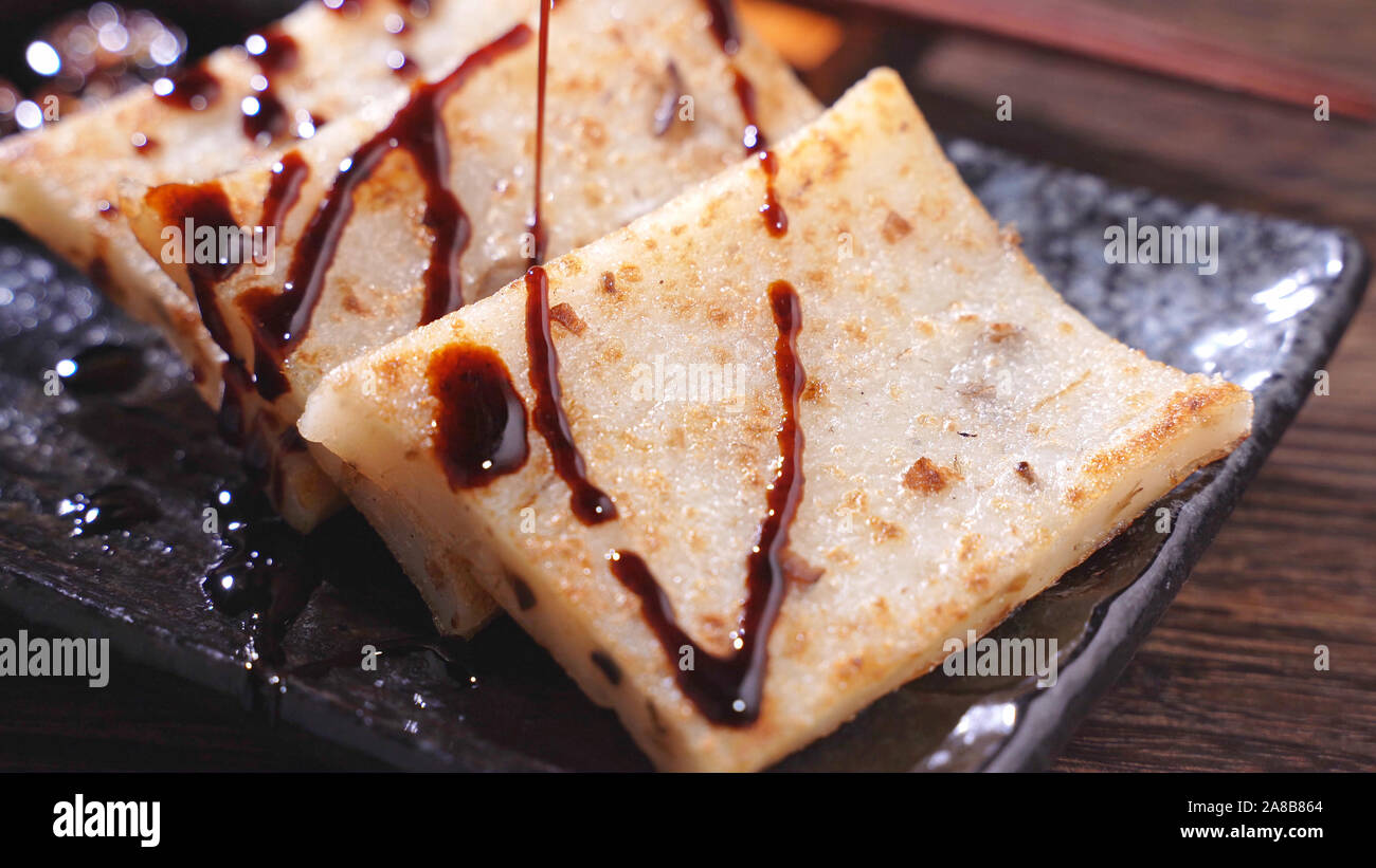 Pouring Black Soy Sauce On Ready To Eat Delicious Turnip Cake