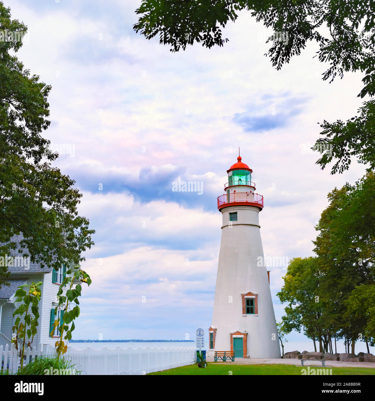 Marblehead Lighthouse on Lake Erie, the oldest Great Lakes lighthouse circa 1820s, Autumn blue hour travel scenic with copy space framed by trees Stock Photo