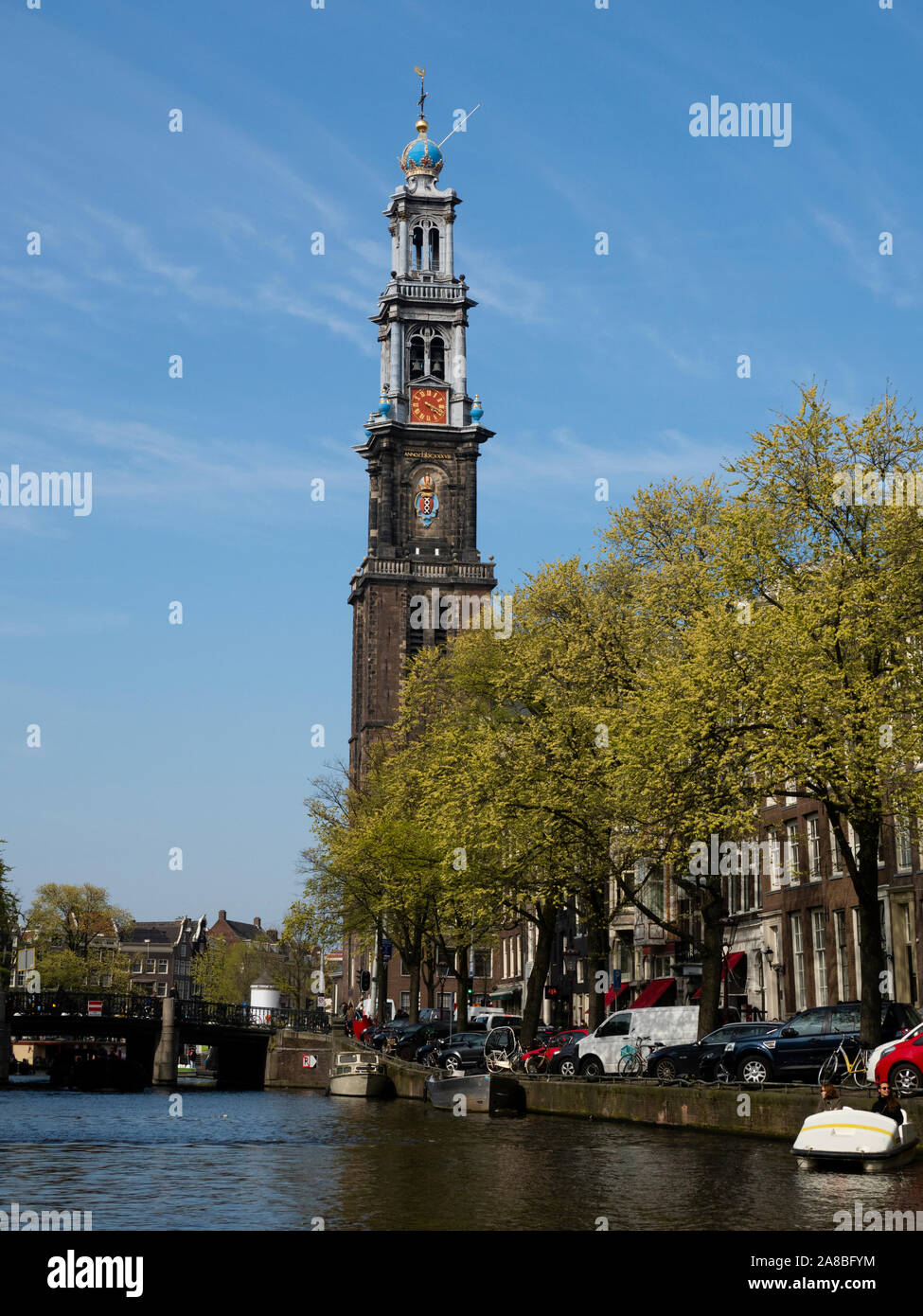 Steeple of Westerkerk rising above canal, Amsterdam, North Holland, Netherlands Stock Photo