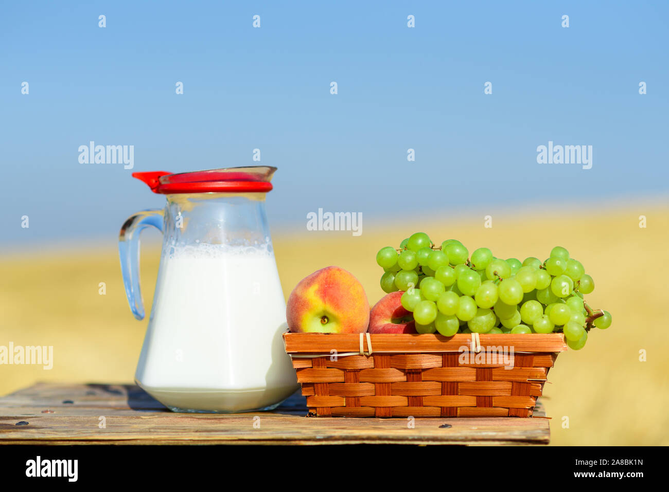 First fruits habikkurim in hebrew and milk on wooden table. Symbols of