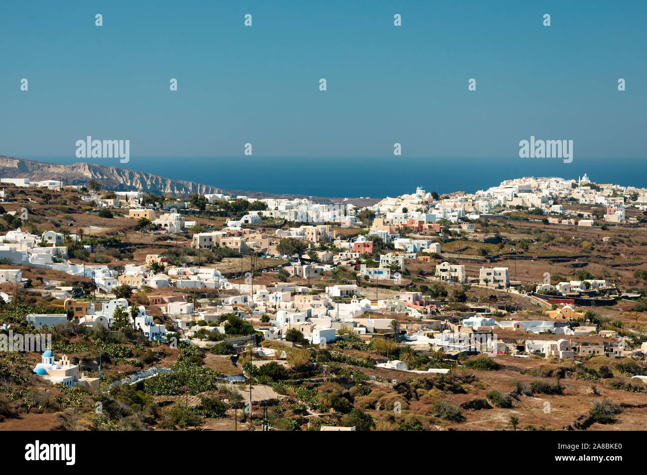 Small villages of white buildings with the ocean in the background on