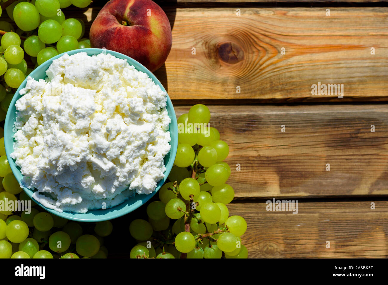 Plate Of Homemade Cottage Cheese Grapes And Peach On Wooden