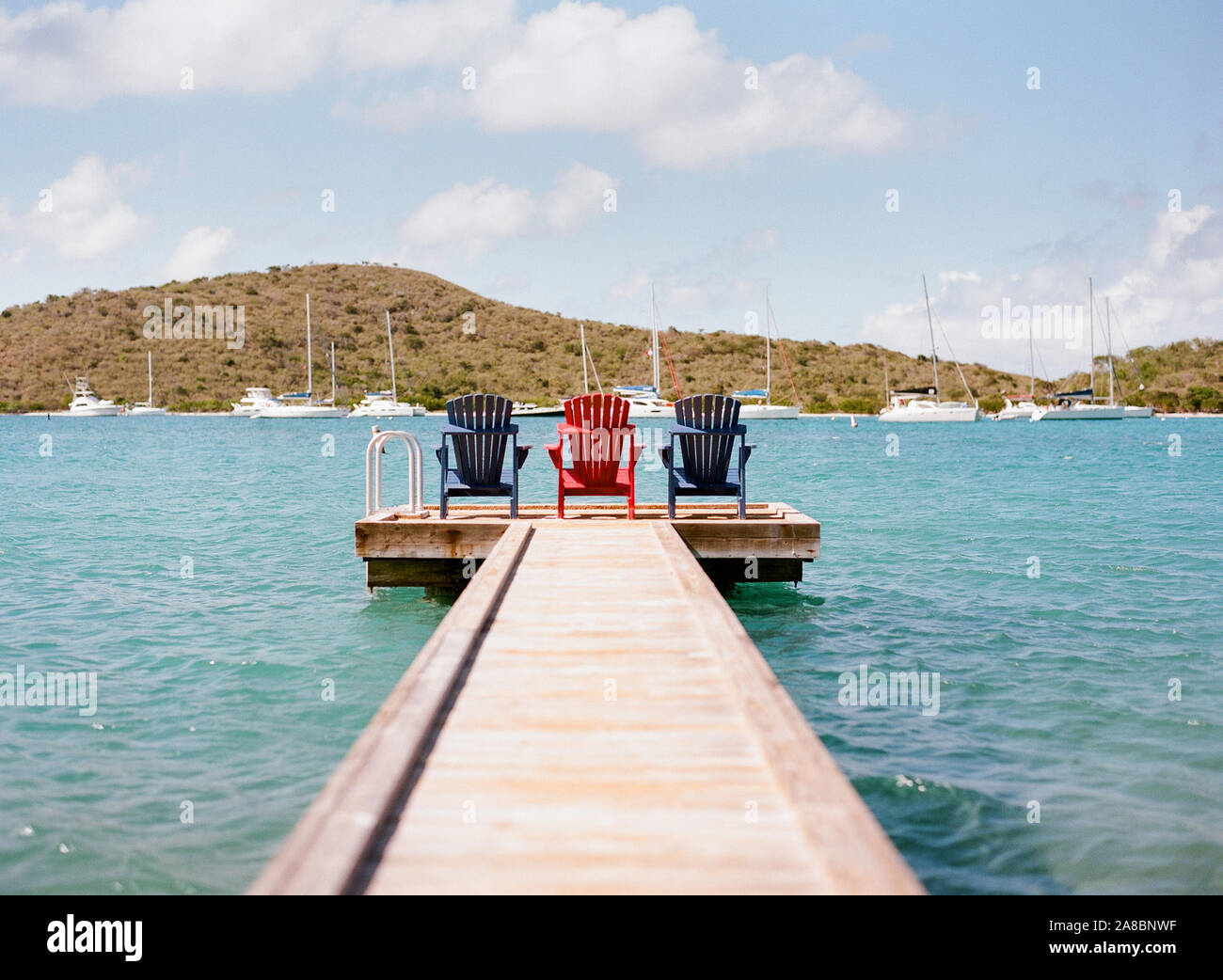 Colorful deck chairs sitting on a pier at the Bitter End Yacht Club on Virgin Gorda Island, British Virgin Islands, Caribbean Stock Photo
