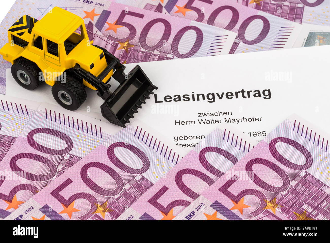 Der Leasingvertrag fuer einen neuen Bagger. Mit Eurogeld und Kugelschreiber Stock Photo