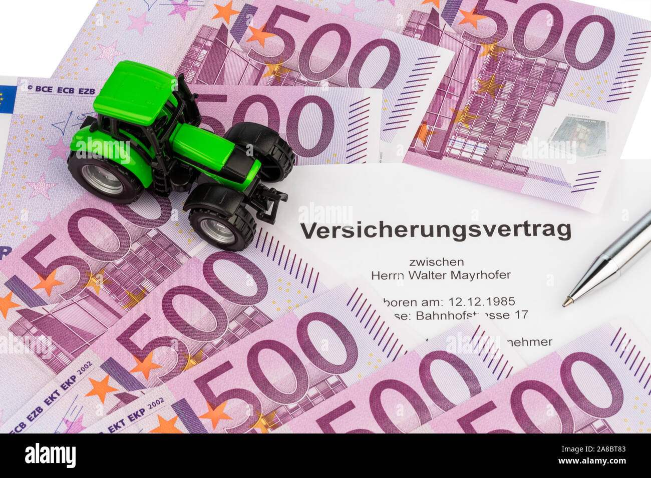 Der Vertrag einer Versicherung fuer einen neuen Traktor. Mit Eurogeld und Kugelschreiber. Stock Photo