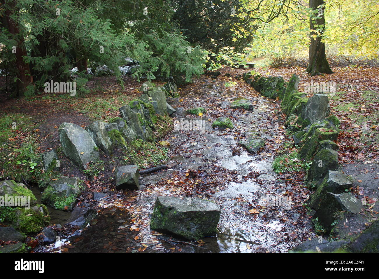 Autumn scene. Small creek with low water, borderd by natural primeval rocks. Stock Photo