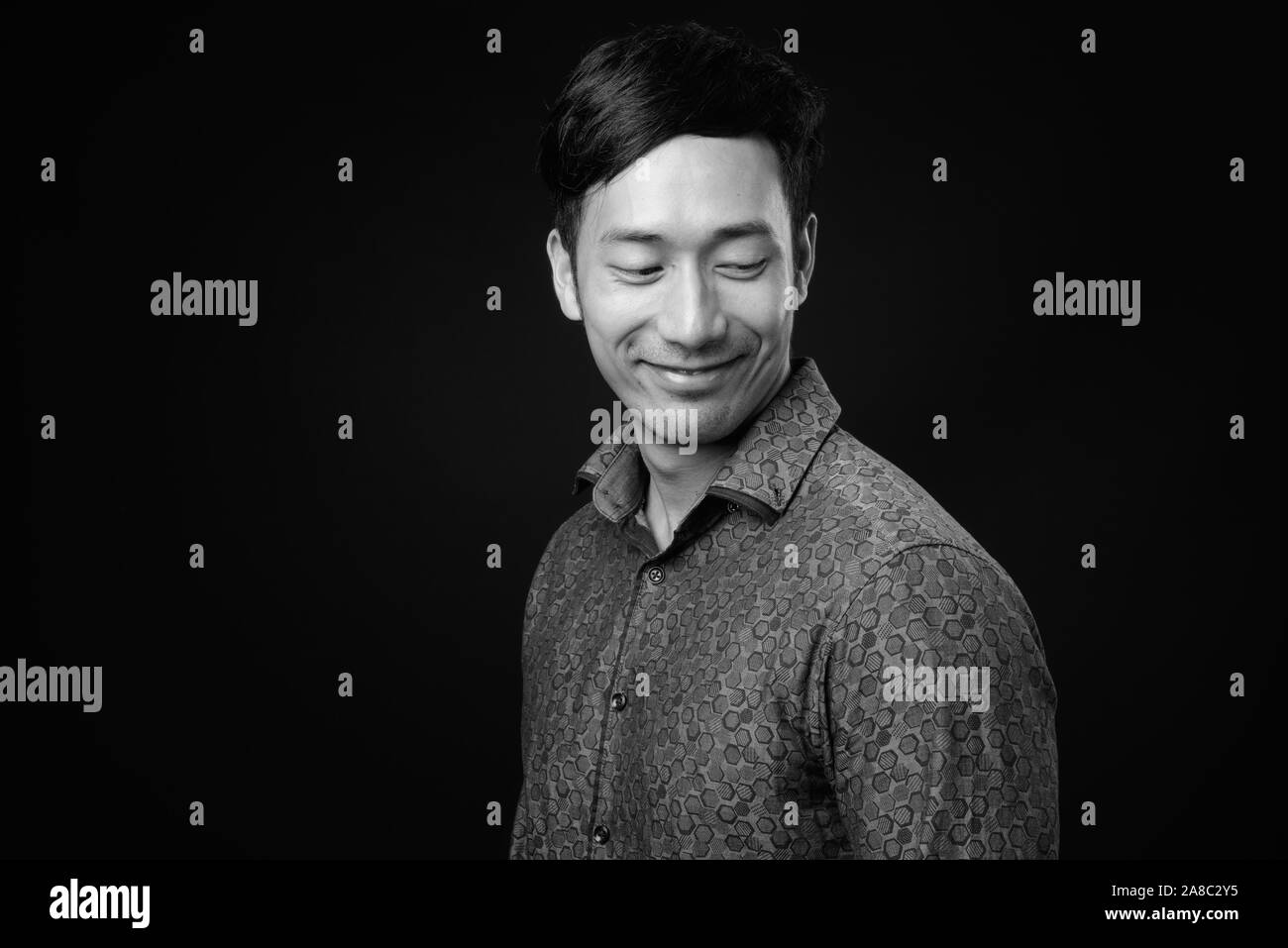 Young handsome Asian businessman against black background Stock Photo