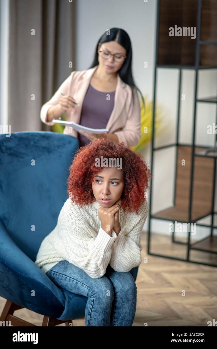 Woman speaking with psychologist while sitting in armchair Stock Photo Alamy