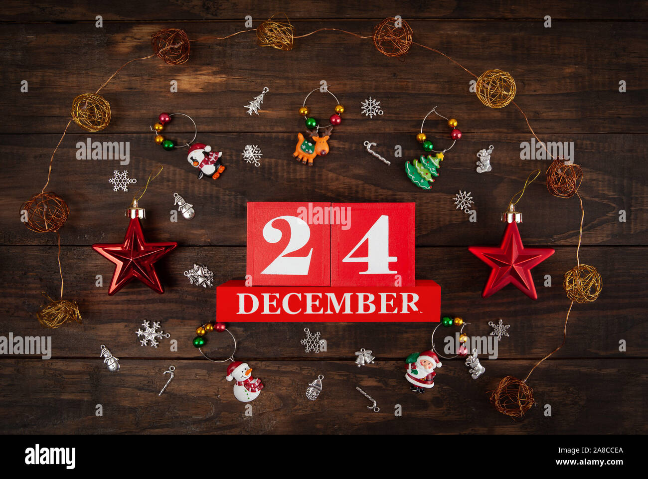 December 24th - Christmas Eve concept depicted with the date and decorations arranged on wooden 