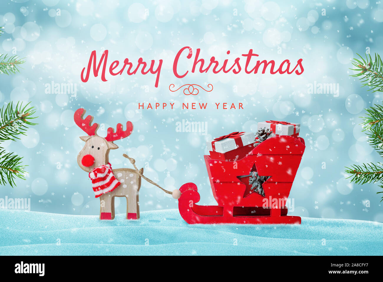 Merry Christmas greeting card with cute toy of Santa's reindeer sleigh full of gifts in snow. Stock Photo
