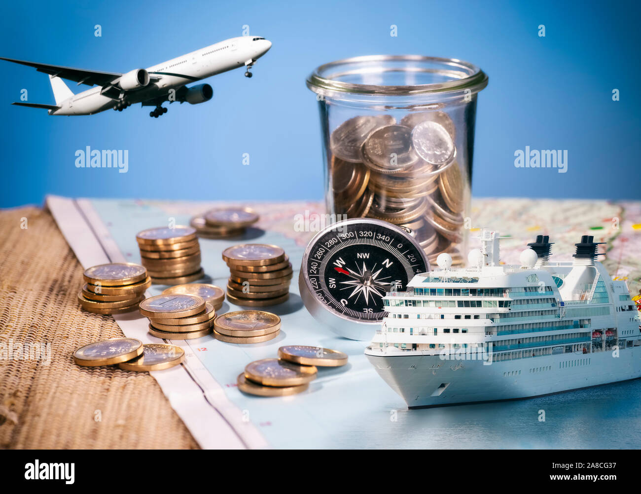 Airplane and cruise ship with compass and coins on a map Stock Photo