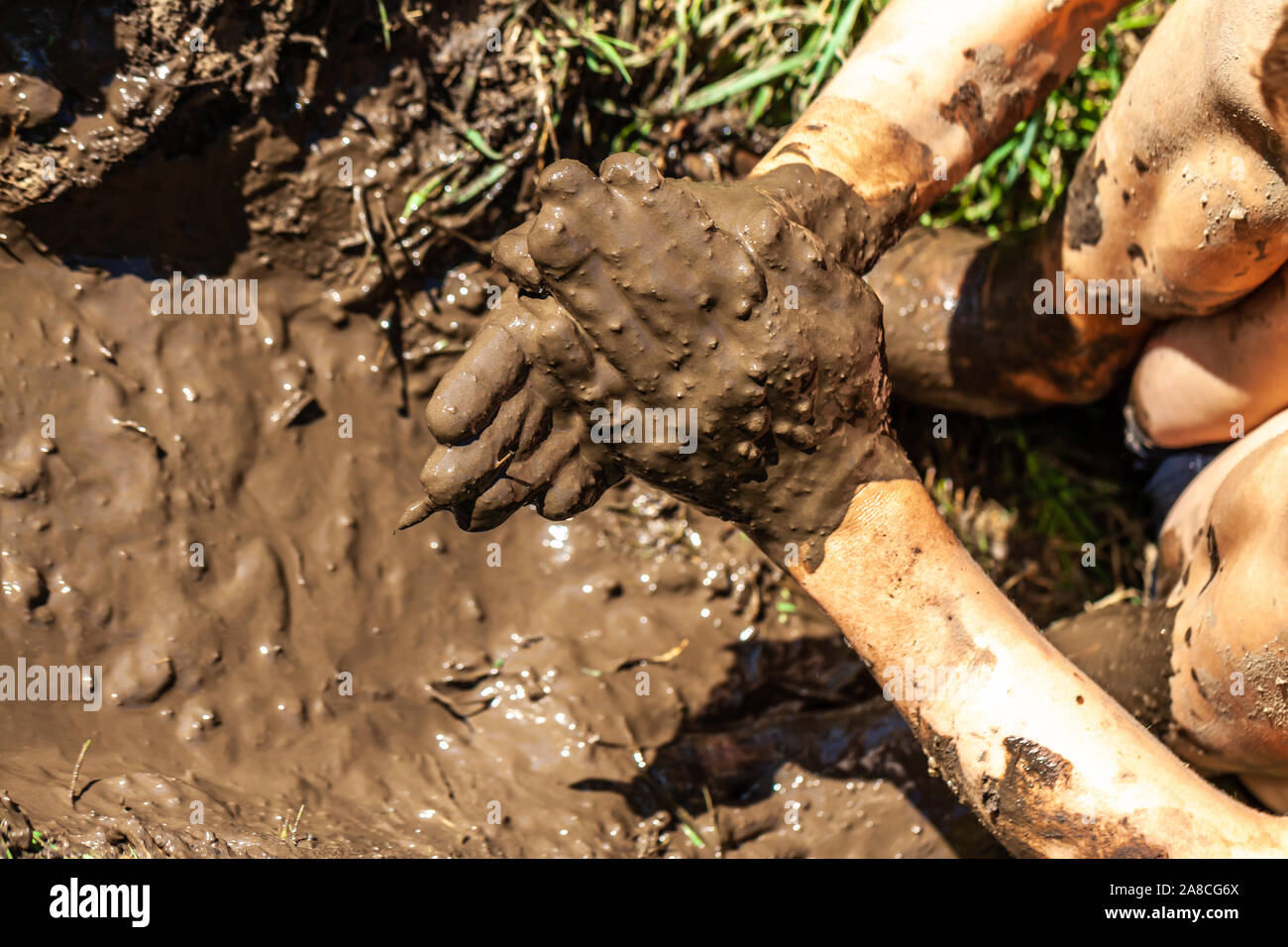 Boy working and playing in the mud. Stock Photo