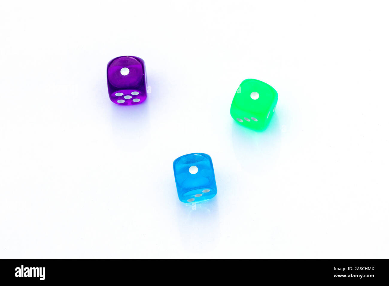three multi-colored dice with the number one on the sides on white background Stock Photo