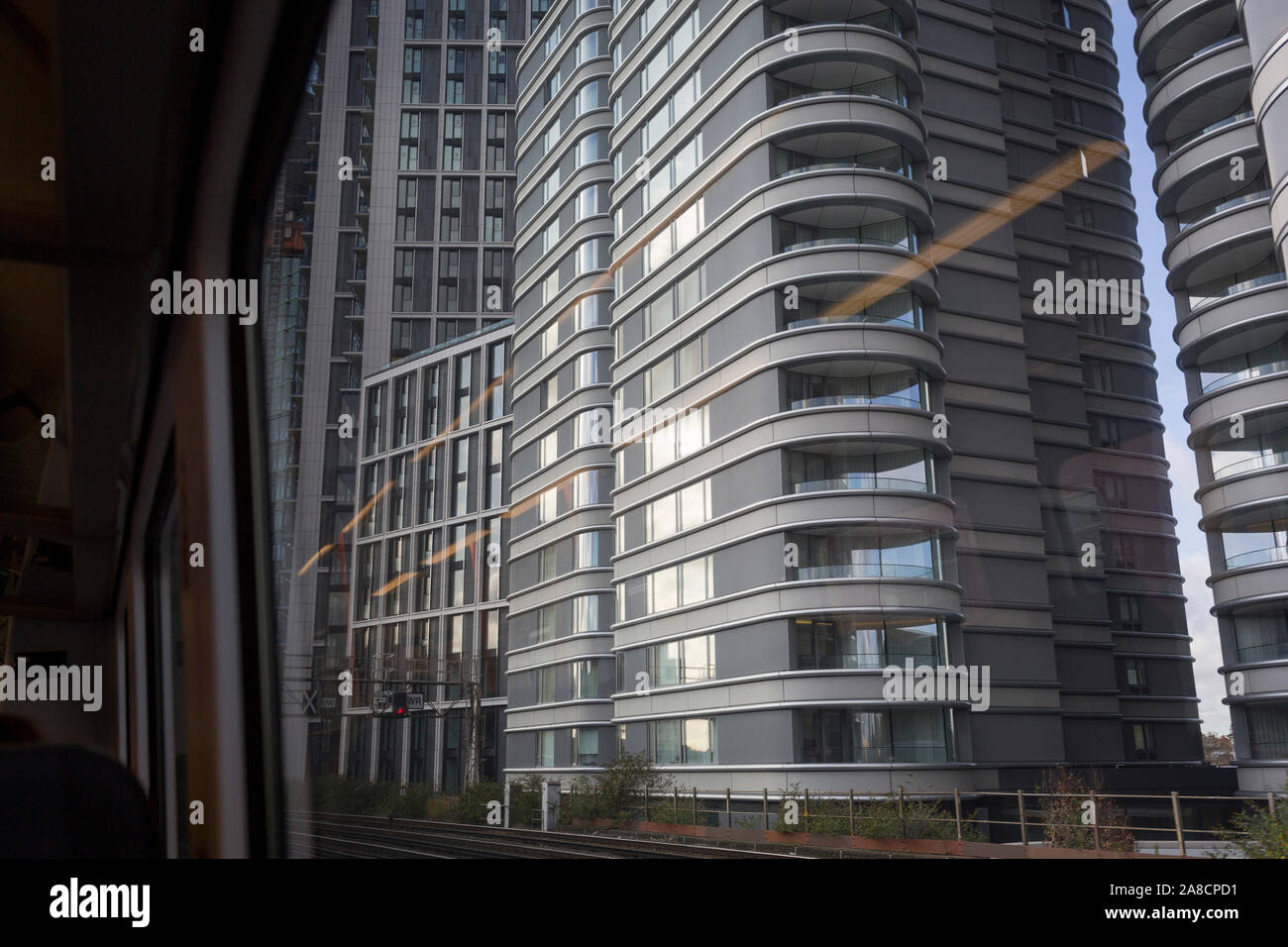 Trackside apartments and flats at the Nine Elms regeneration development in Battersea, seen through the window of a Southern train carriage window, on 7th November 2019, in London, England Stock Photo