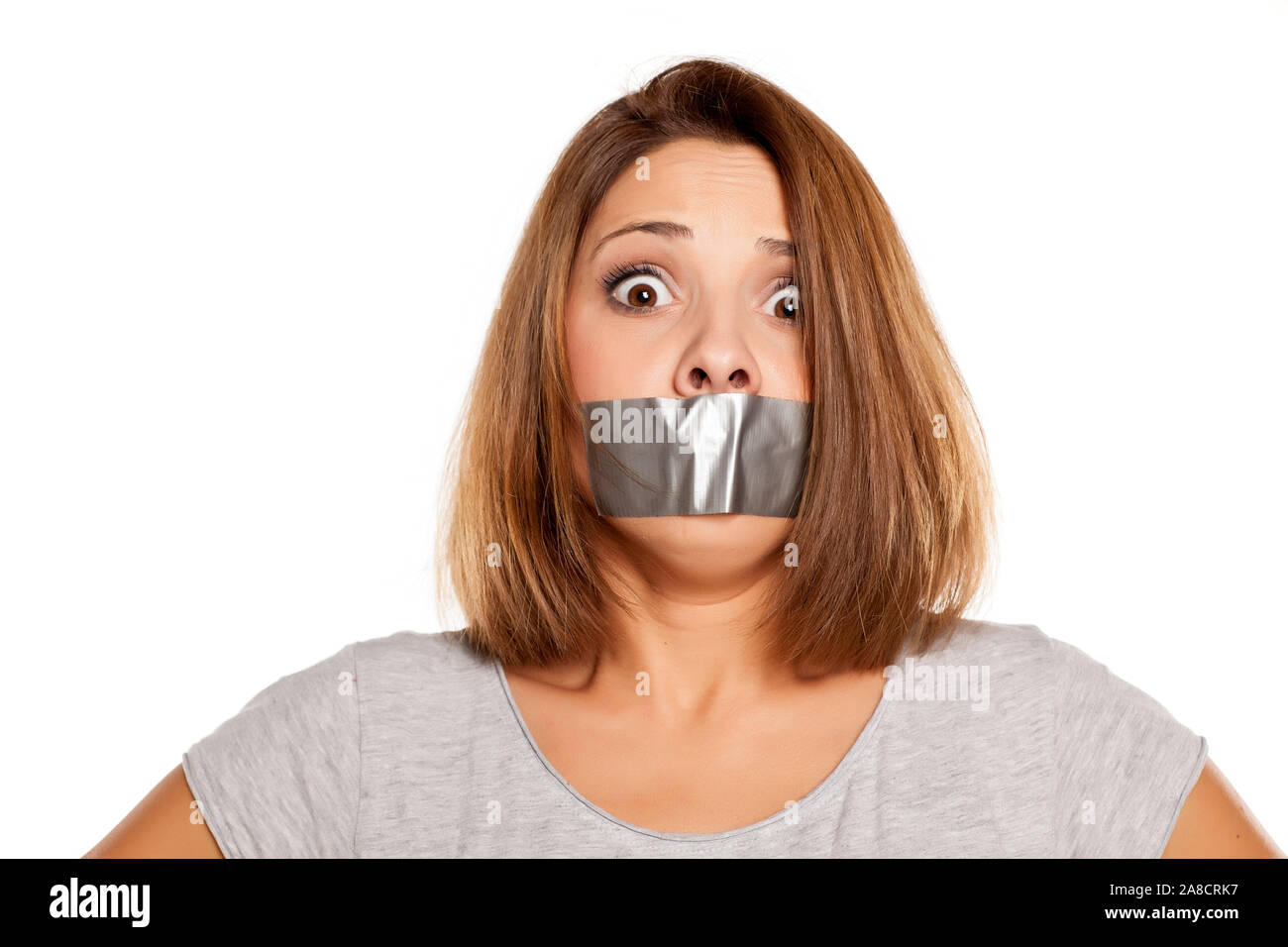 scared young woman with adhesive tape over her mouth Stock Photo