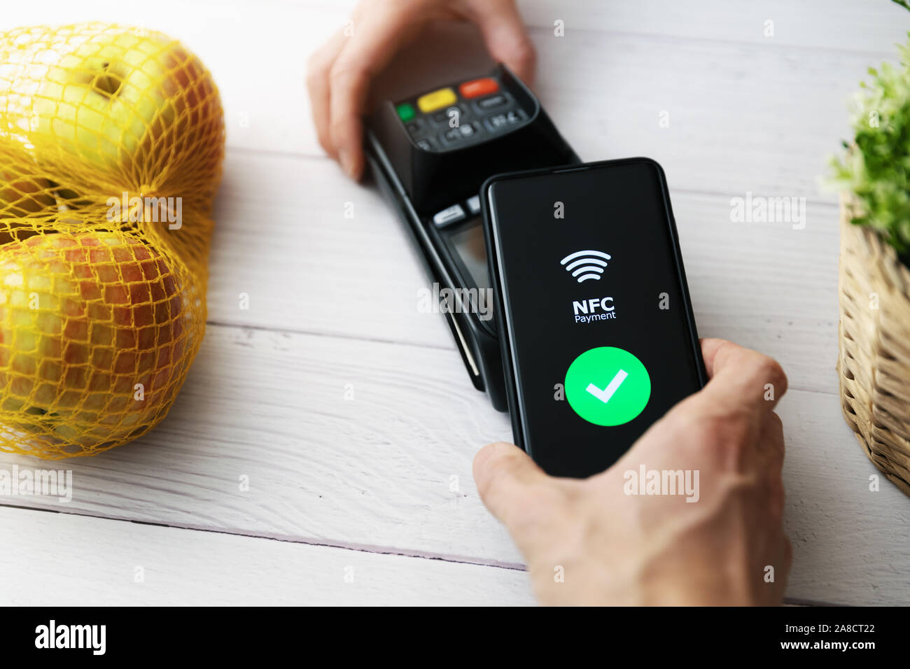 nfc contactless payment with phone at groceries store Stock Photo