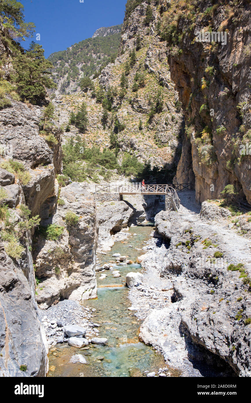 Agia Roumeli, Samaria National Park, Chania, Crete, Greece. Hiker crossing footbridge over river in the Samaria Gorge. Stock Photo