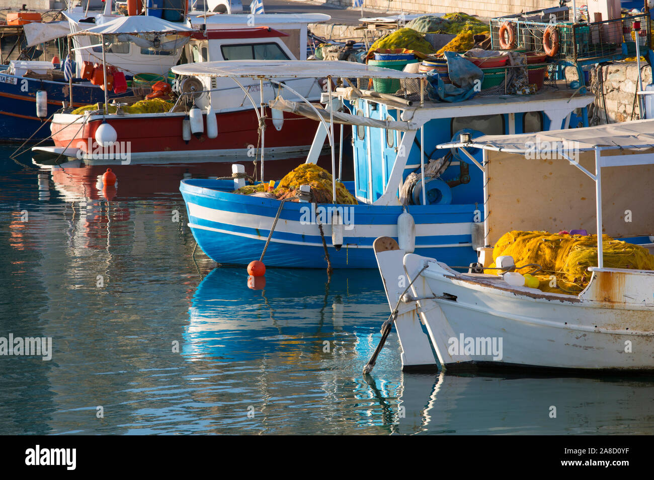 Heraklion, Crete, Greece. Fishing boats reflected in the tranquil waters of the Venetian Harbour. Stock Photo