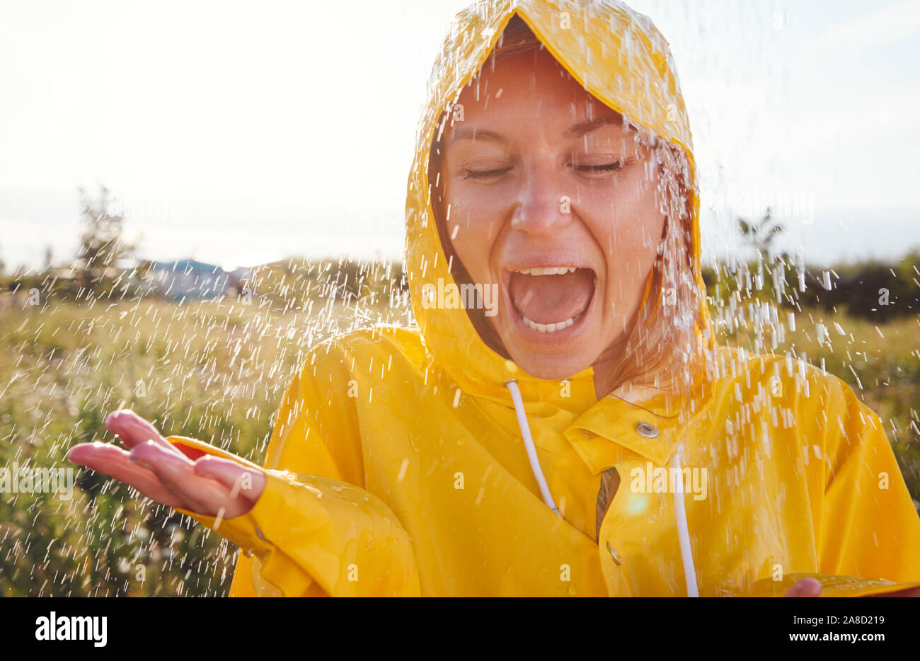 Unhappy Woman In Rain Wearing Waterproof Coat At Outdoor Music Festival  Stock Photo - Alamy