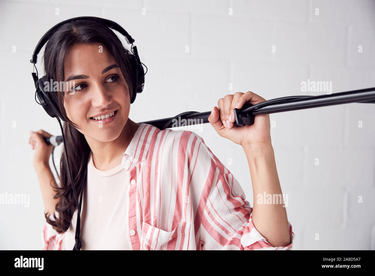 Female Sound Recordist Holding Microphone On Video Film Production In