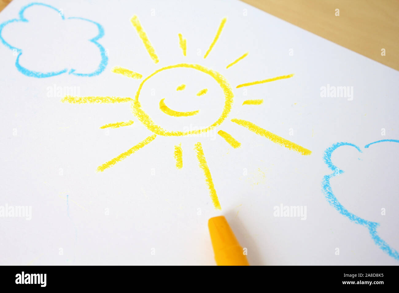 Cute childish drawing by wax crayons. Sun and clouds Stock Photo
