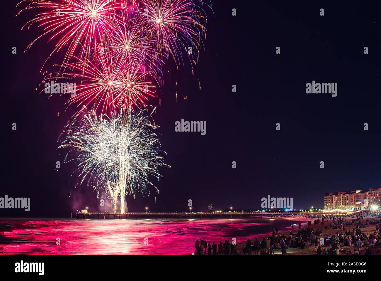 People watching New Year's Eve fireworks display at Glenelg  beach, South Australia Stock Photo
