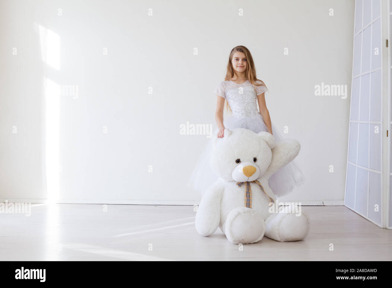 Beautiful little girl with toy big teddy bear Stock Photo - Alamy