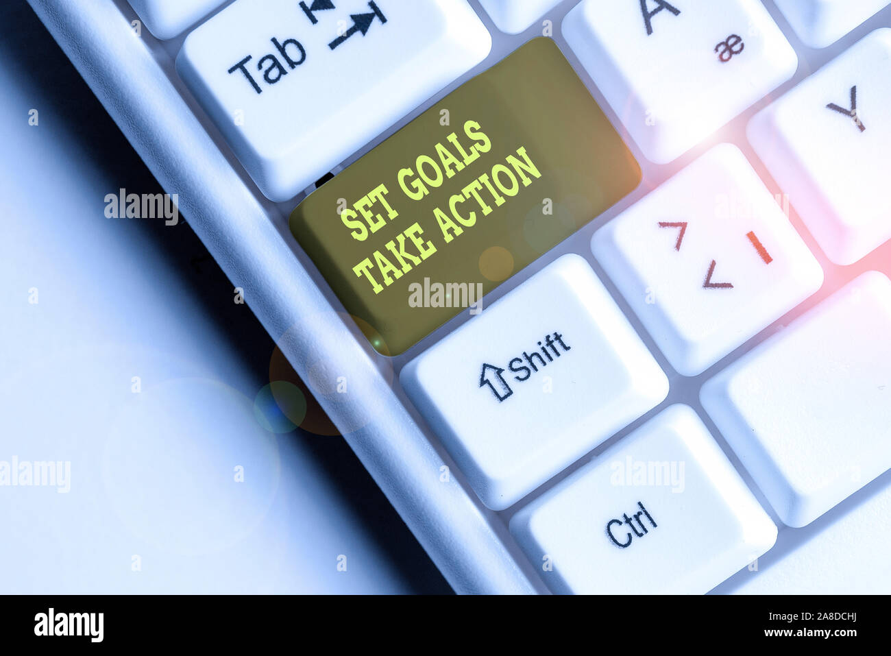 Word writing text Set Goals Take Action. Business photo showcasing Act on a specific and clearly laid out plans White pc keyboard with empty note pape Stock Photo
